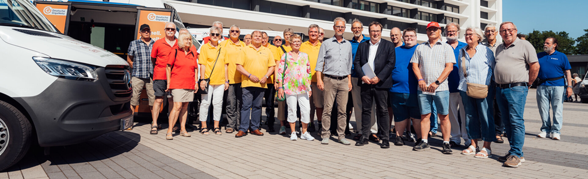 Gruppe von Menschen bei einem Bürgerbustag, aufgestellt neben einem Bürgerbus.