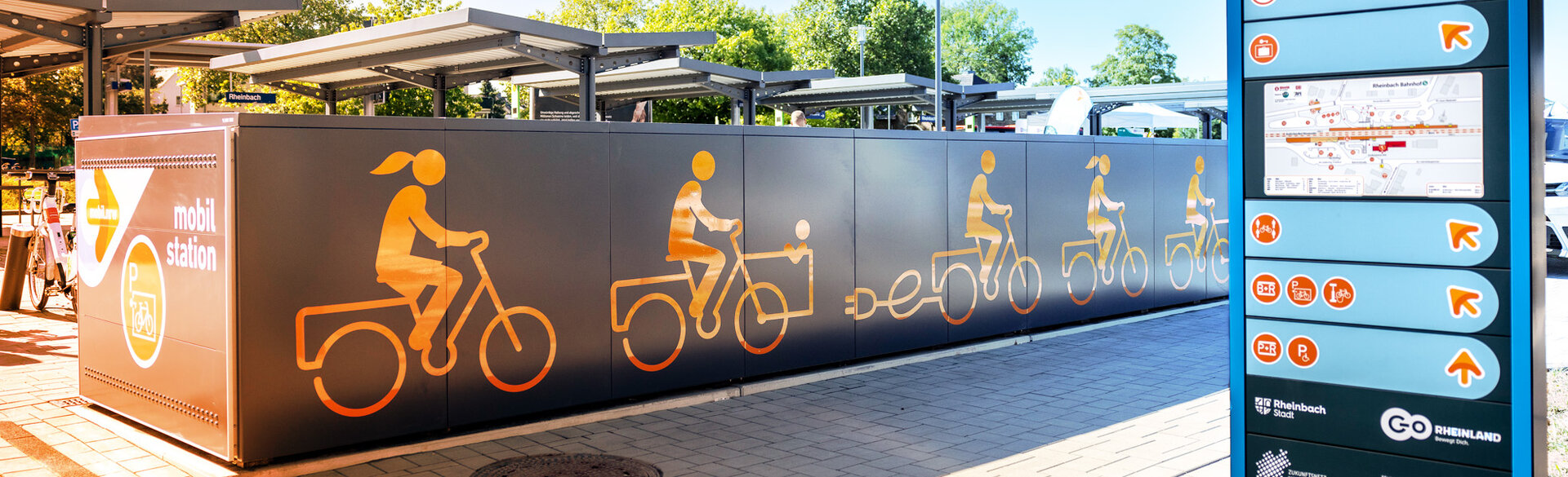Fahrradabstellanlage mit Fahrradsymbol neben einer digitalen Stele mit einer App-Darstellung.