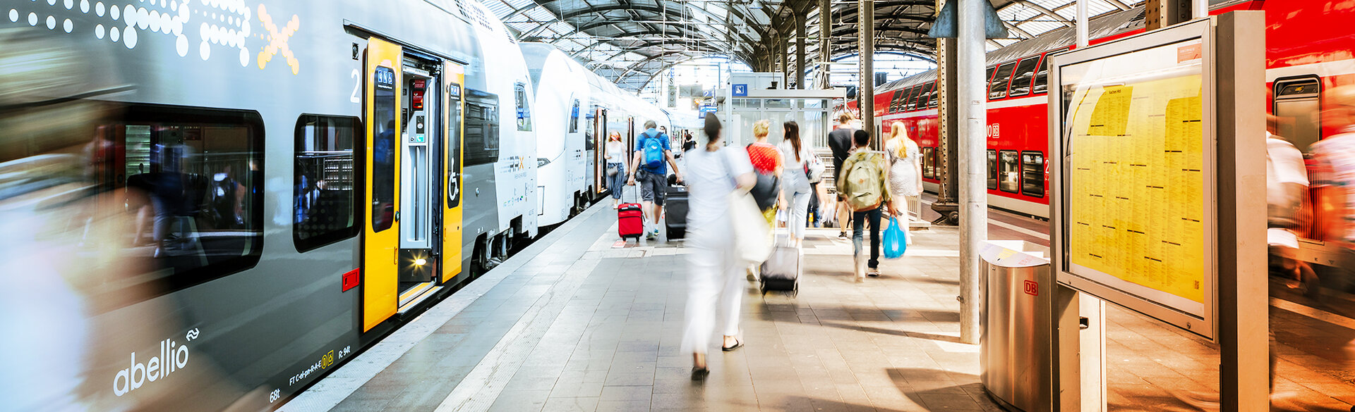 Haltestellenszene mit Stadtbahn und wartenden Fahrgästen.